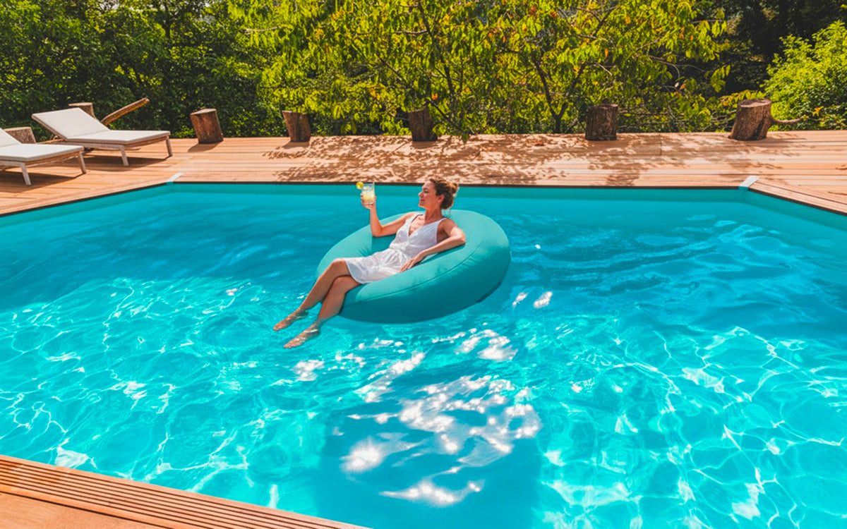 Pouf Rond Piscine Turquoise flottant sur l’eau de la piscine, moment détente en extérieur