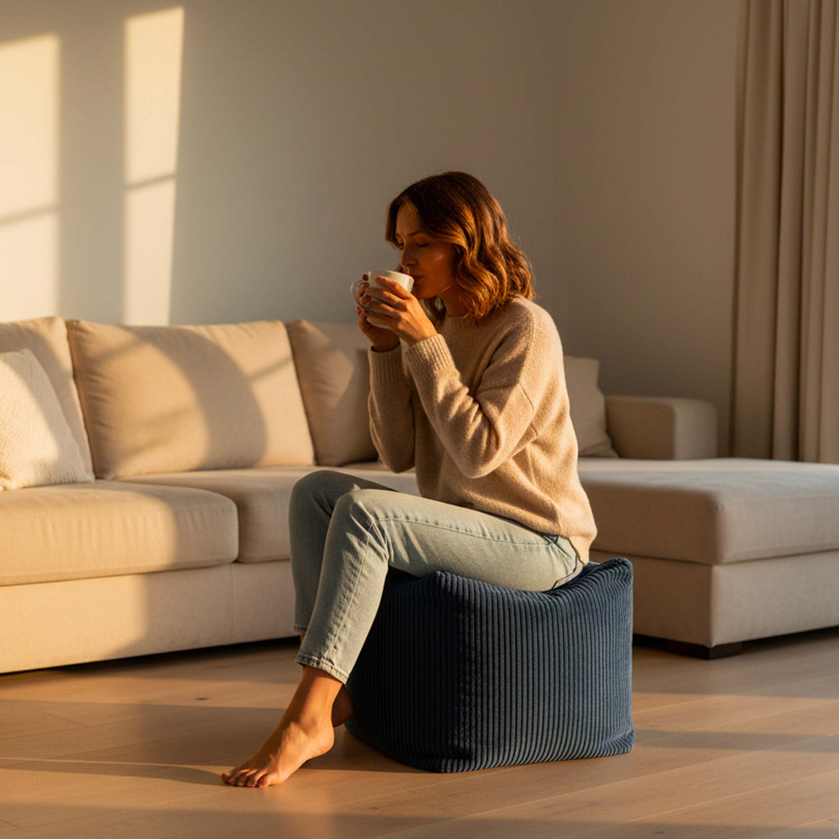 Pouf Cube Velours Côtelé Bleu Marine, pouf cube en velours côtelé bleu marine utilisé comme repose-pieds dans un salon