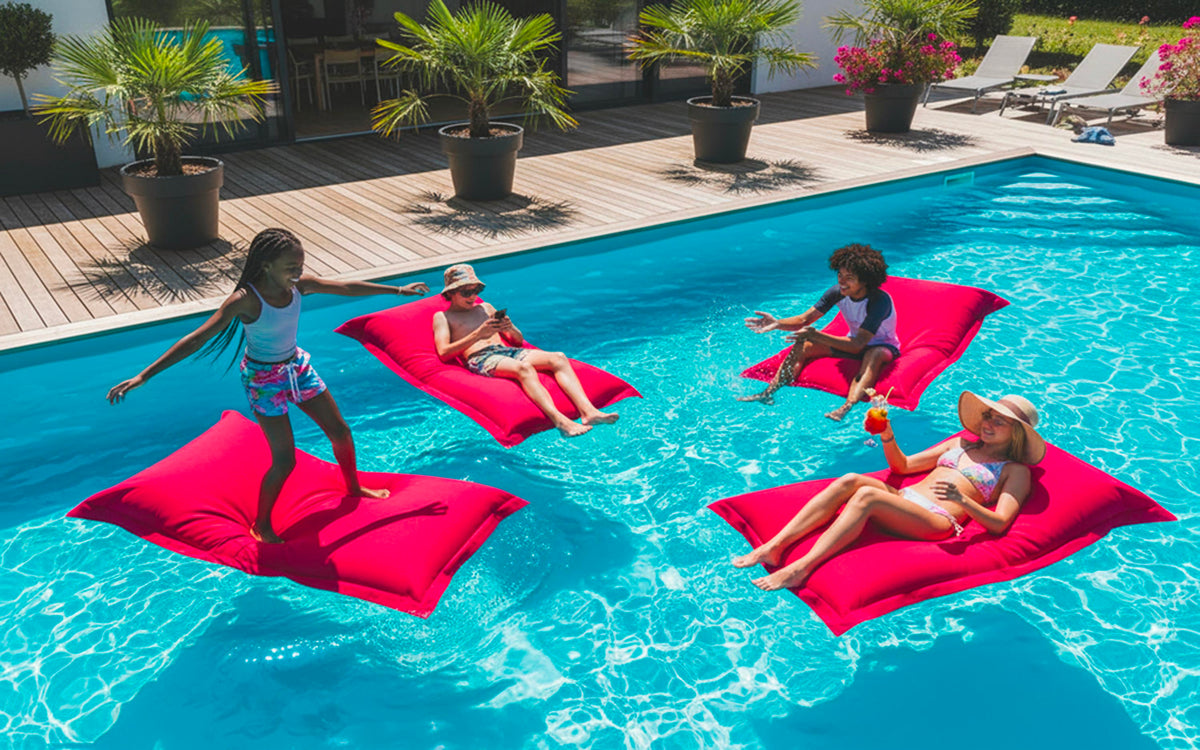 Pouf Piscine Rose BiG52 XXL déhoussable, flottant avec billes de polystyrène dans une piscine extérieure en été