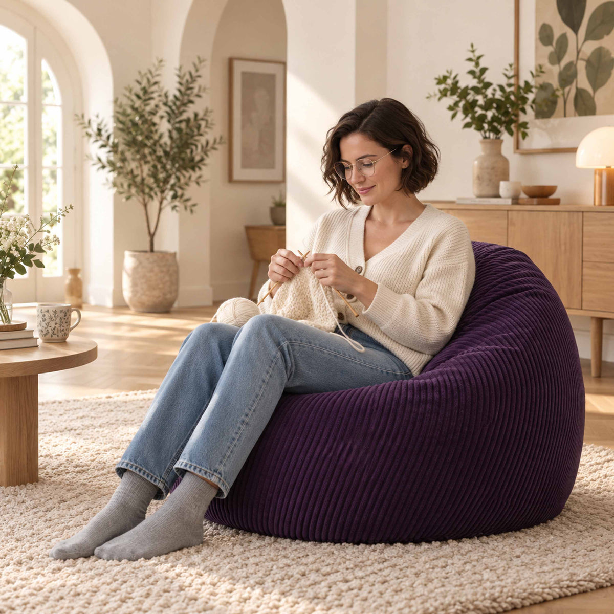 Pouf Poire Velours Côtelé Violet aubergine, assise confortable en velours côtelé violet, salon lumineux avec personne
