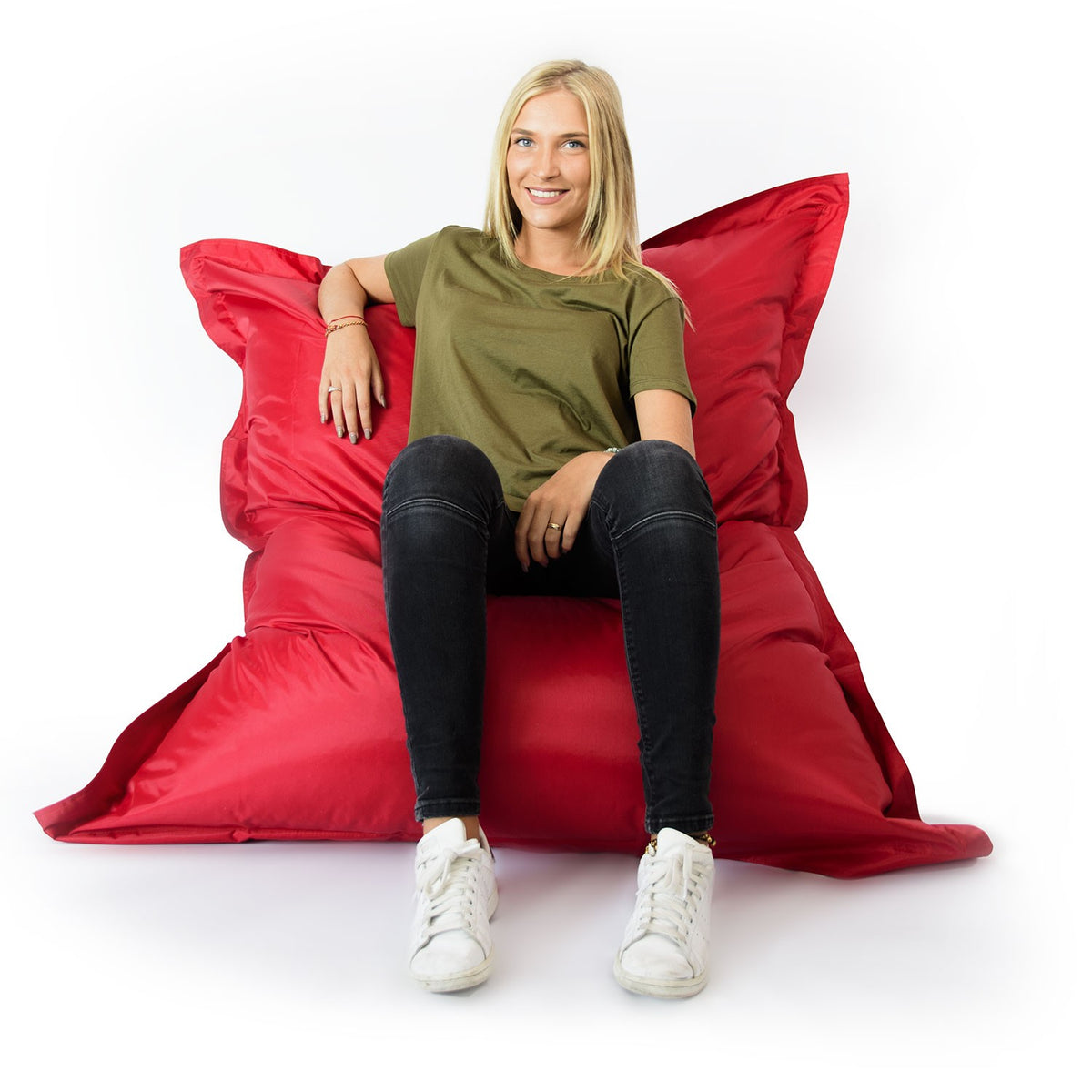 Pouf Géant XL Rouge : femme assise confortablement sur un pouf géant XL en rouge, style moderne pour salon ou chambre