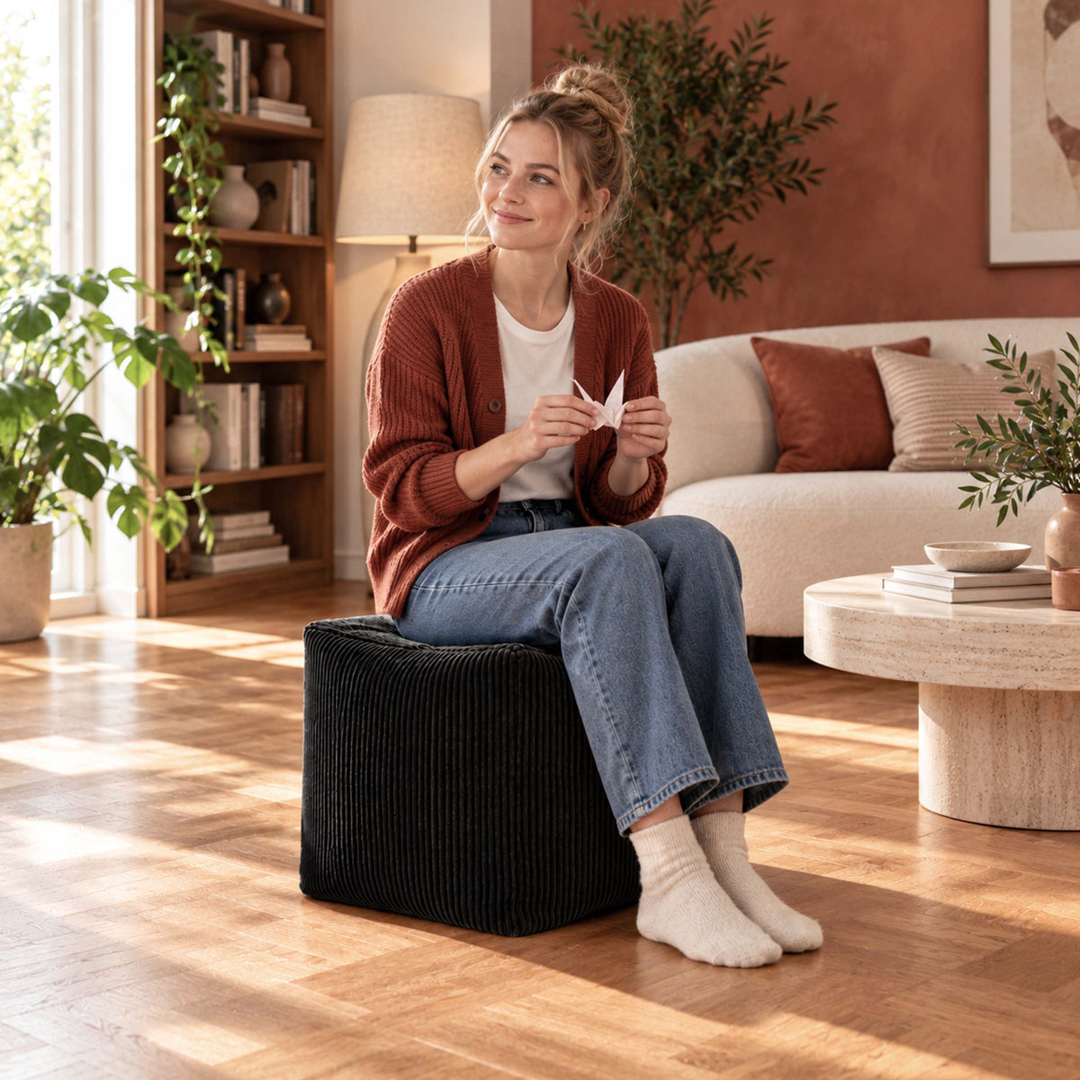 Pouf Cube Velours Côtelé Noir : assise d’appoint et repose-pieds en velours côtelé noir, dans un salon chaleureux