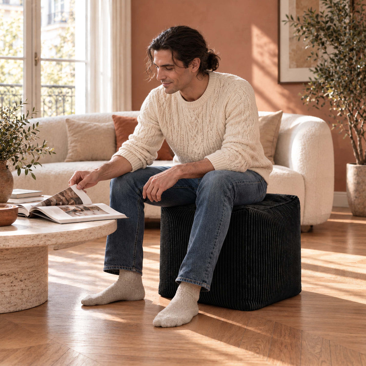 Pouf Cube Velours Côtelé Noir, assise et repose-pieds en velours côtelé, design compact dans un salon lumineux