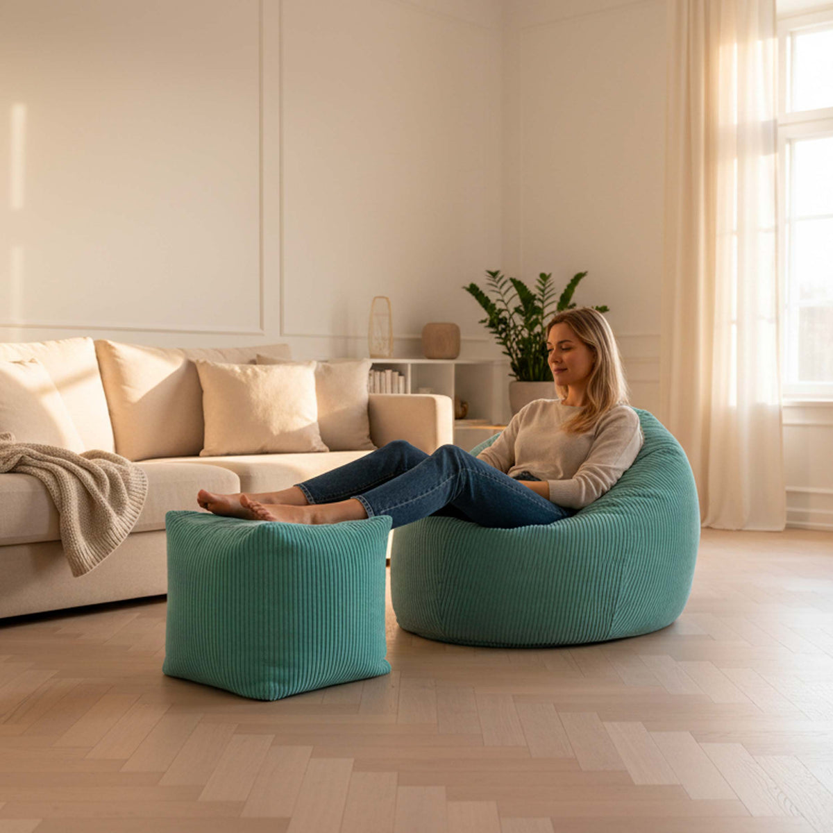 Pouf Cube Velours Côtelé Turquoise en velours côtelé, assise d’appoint ou repose-pieds, dans un salon lumineux avec canapé