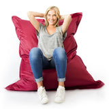 Pouf Géant XL Bordeaux, photo d’une femme assise et détendue sur le pouf XXL bordeaux style salon, chambre ou jardin