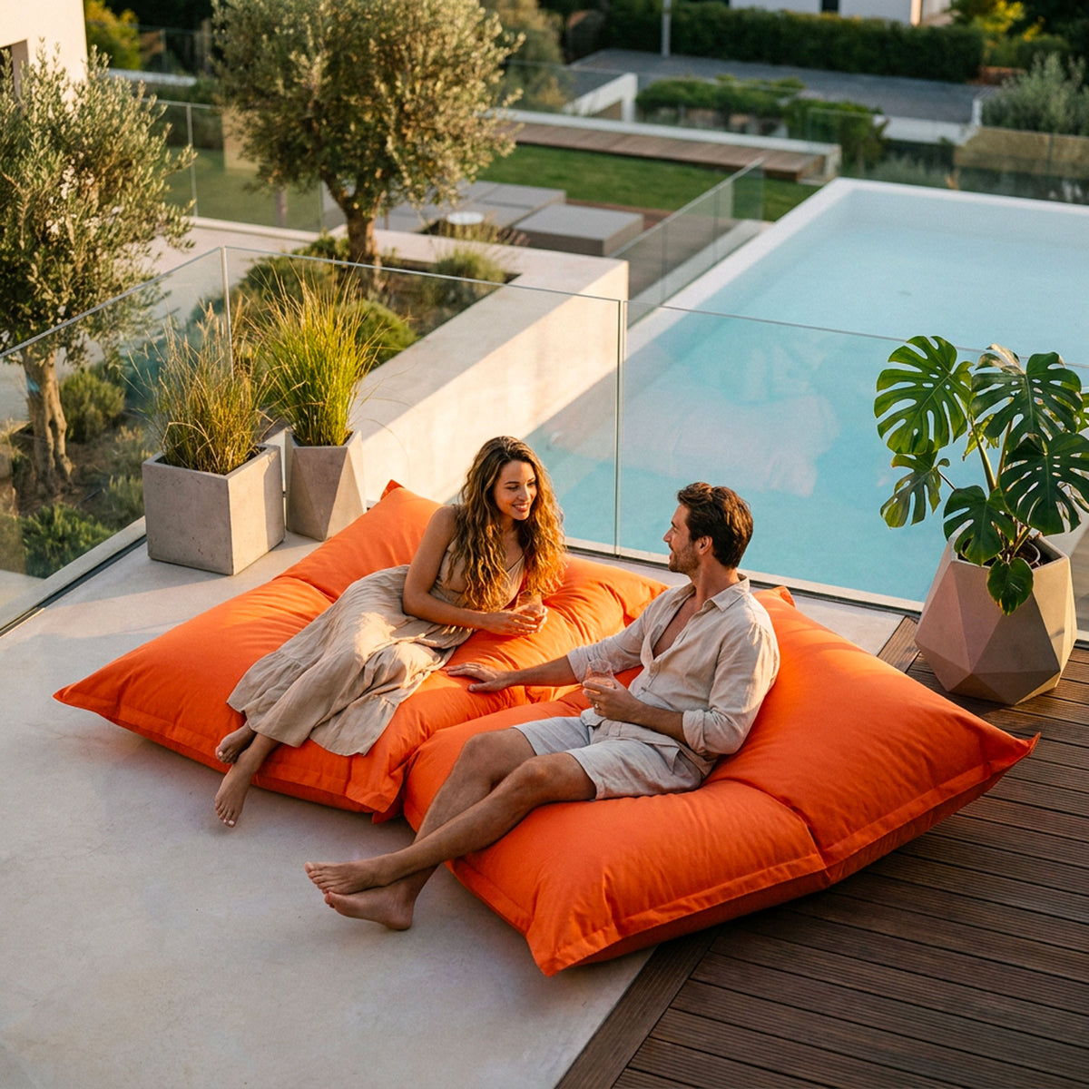 Pouf Géant XXL Orange BiG52 Classic : couple se relaxant près de la piscine en extérieur, modèle XXL orange Edition Classic