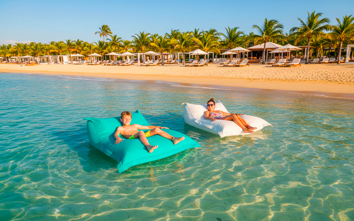 Pouf Piscine Turquoise BiG52 XXL déhoussable flottant en mer, billes de polystyrène, confort et design au bord de la plage