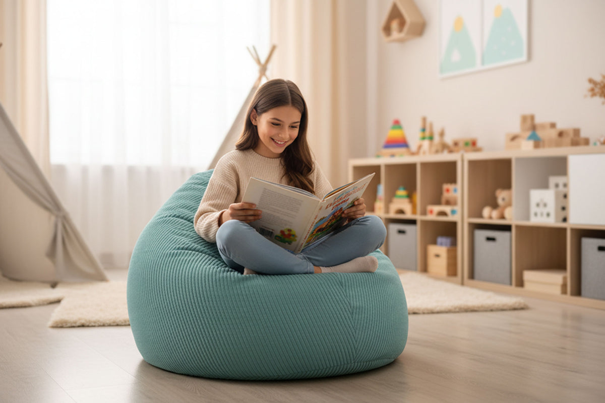 Pouf Poire Velours Côtelé Turquoise, enfant assise lisant dans un salon, velours côtelé turquoise rempli de billes polystyrène
